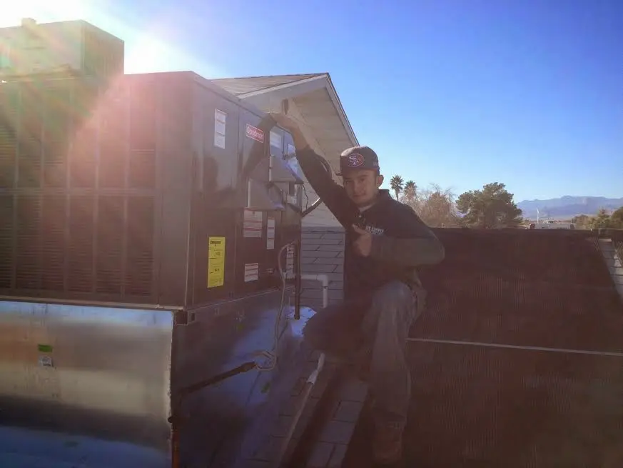 HVAC technician performing Air Duct Cleaning on a rooftop unit in Hailey